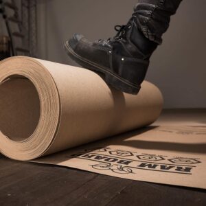 Someone using their foot to roll out ram board on the ground