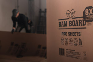 Un rouleau de feuilles RAM Board Pro avec quelqu'un qui le déroule en arrière-plan