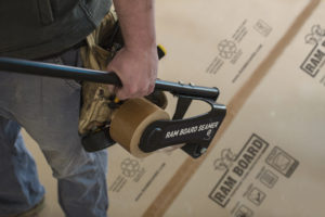 Closeup of a construction worker's hand holding ram board seamer product