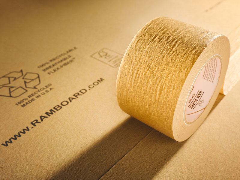 close up view of a roll of brown ram board seam tape on paperboard floor protection