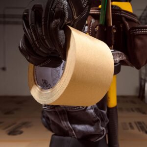 worker holding a roll of ram board seam tape