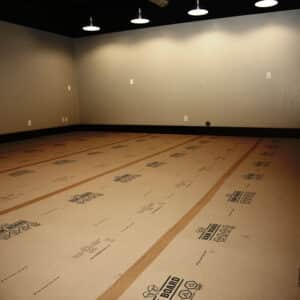 Ram board floor protection laid out on the floor of a large empty room