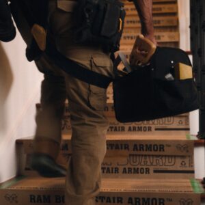 worker walking up steps, on top of ram board stair armor