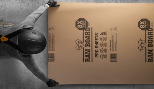 ram board pro sheet floor protection laid on cement floor by man in hardhat and gloves